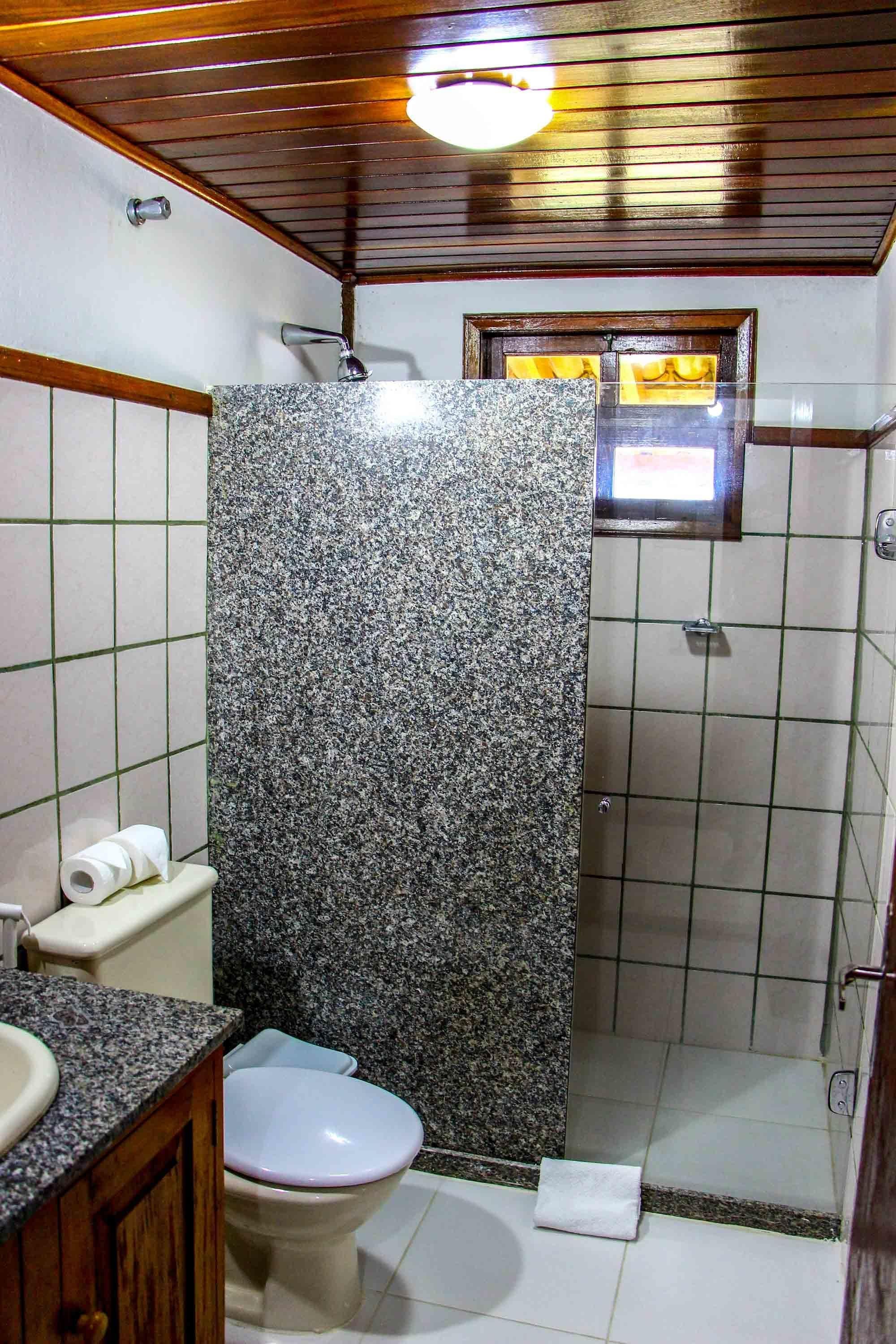 Ein Badezimmer mit Dusche, Toilette und Waschbecken.