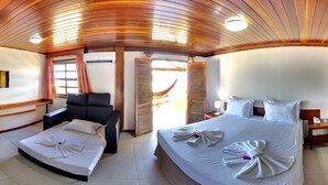 Una habitación de hotel con una cama, una silla, un escritorio y una ventana con cortinas.