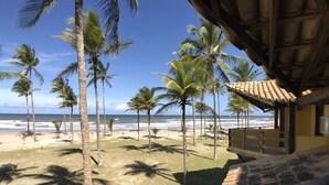 Vista de una playa con palmeras y un edificio de techo a ladrillo.
