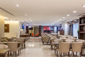 Enjoy meals in our spacious dining area with a long table and comfortable seating, leading to a welcoming reception area.