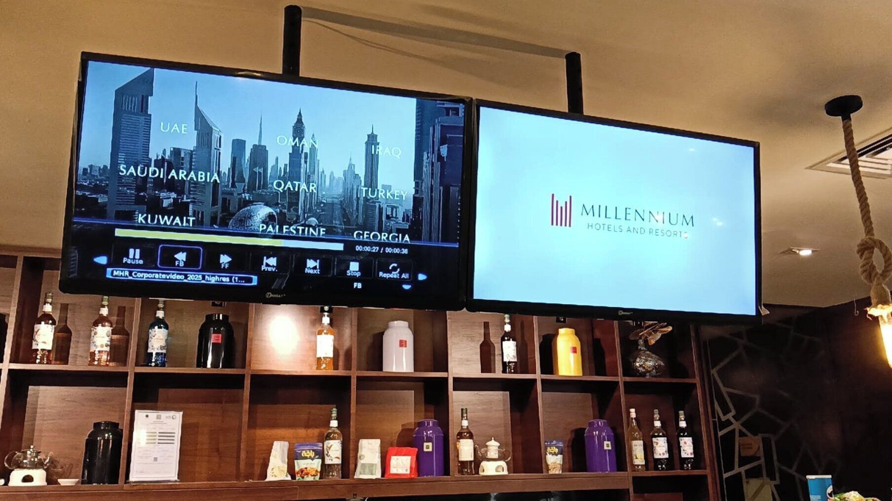 Two screens displaying cityscapes and a hotel name.