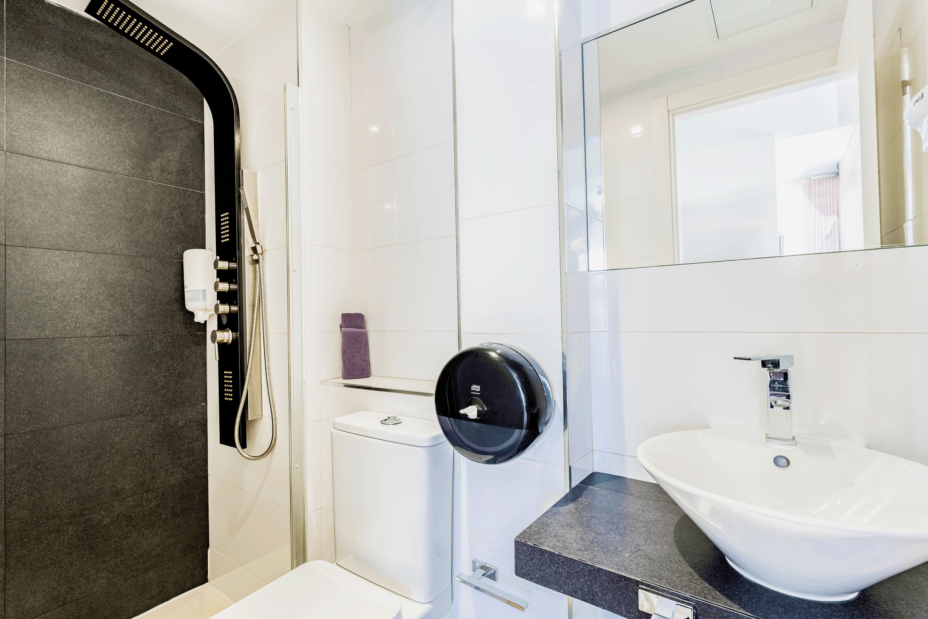 Une salle de bain moderne équipée de toilettes, d’un bidet et d’un lavabo.