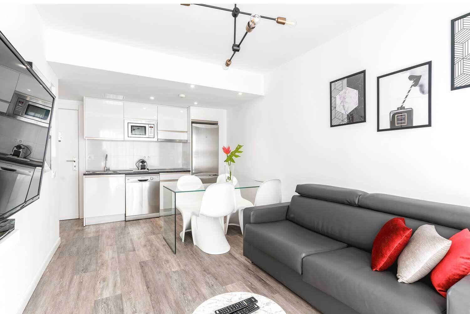A modern apartment with a kitchen, dining area, and living room.