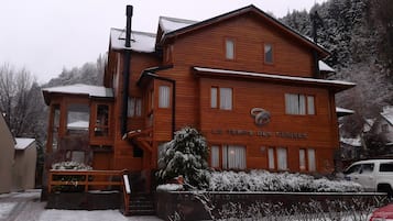 A two-story wooden building with a sign reading "LE TEMPS DES CERISES".