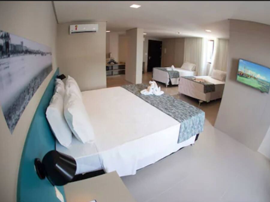 Une chambre d’hôtel avec un grand lit, un bureau, une chaise, un canapé et une télévision.
