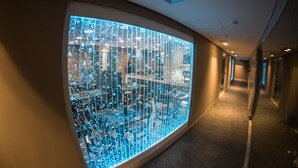 A corridor with a large illuminated display on one wall. - Acqua Suites (Maceió)