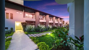 A hotel with a courtyard, multiple balconies, and a night sky. - Hotel Porto Nápolis (Eunapolis)