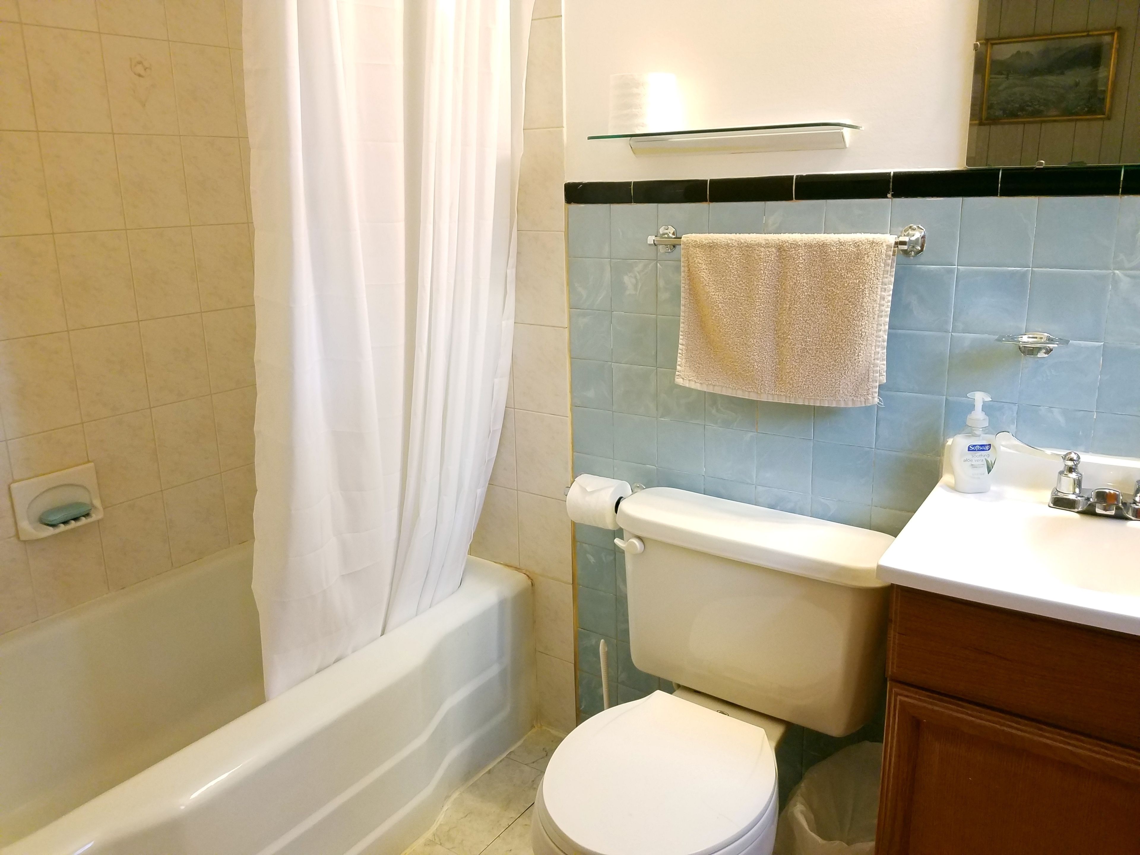 A bathroom with a bathtub, toilet, and sink.