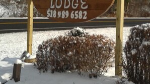 A wooden sign for Black Bear Lodge with a phone number. - Black Bear Lodge (Prattsville)
