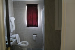 Un baño con inodoro, lavabo y cortina de ducha.