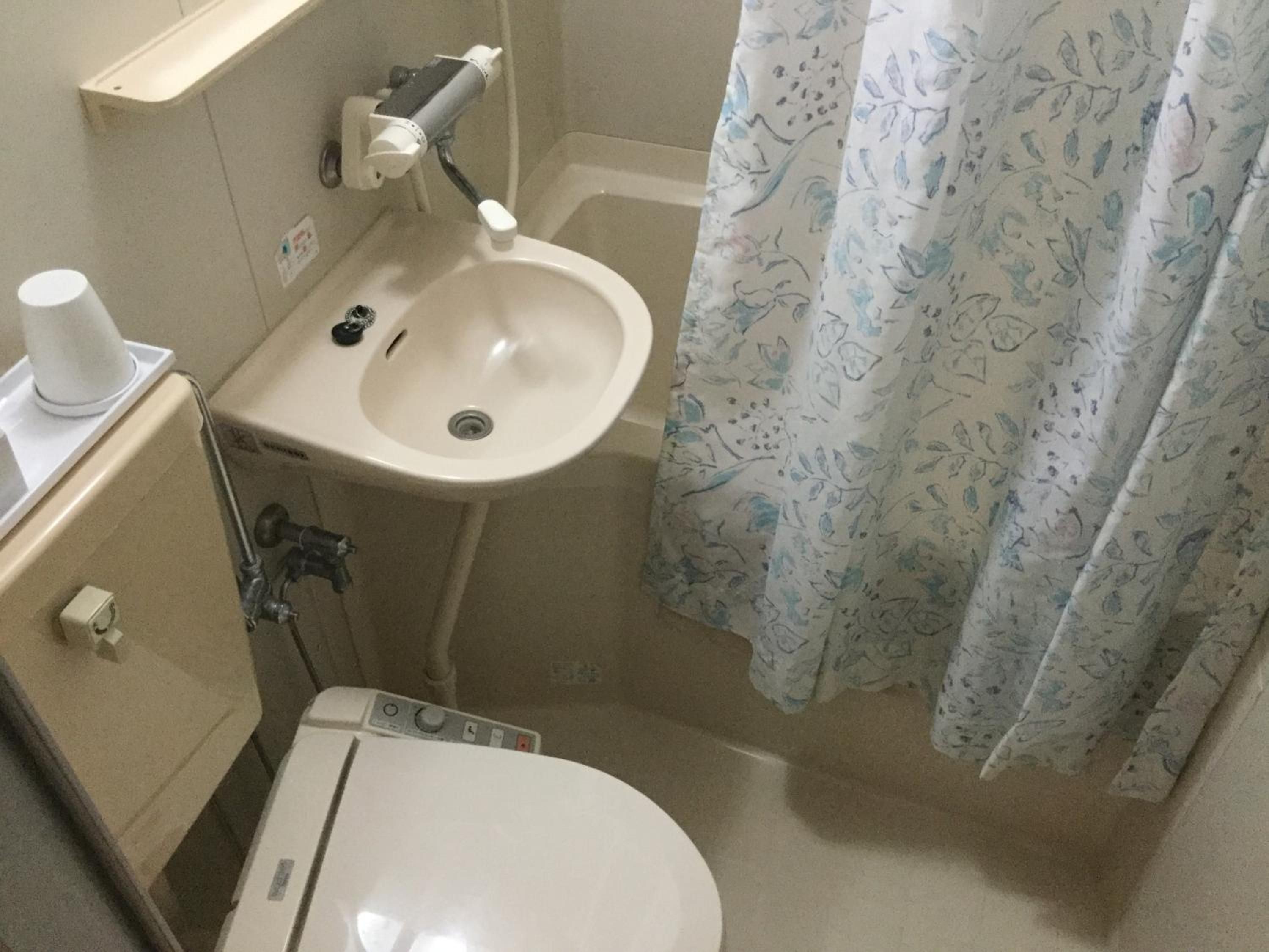 Un baño pequeño con inodoro, lavabo y cortina de ducha.
