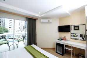 A hotel room with a balcony, a desk, a bed, a TV, and an air conditioning unit. - iCheck inn Sukhumvit 22 (Bangkok)