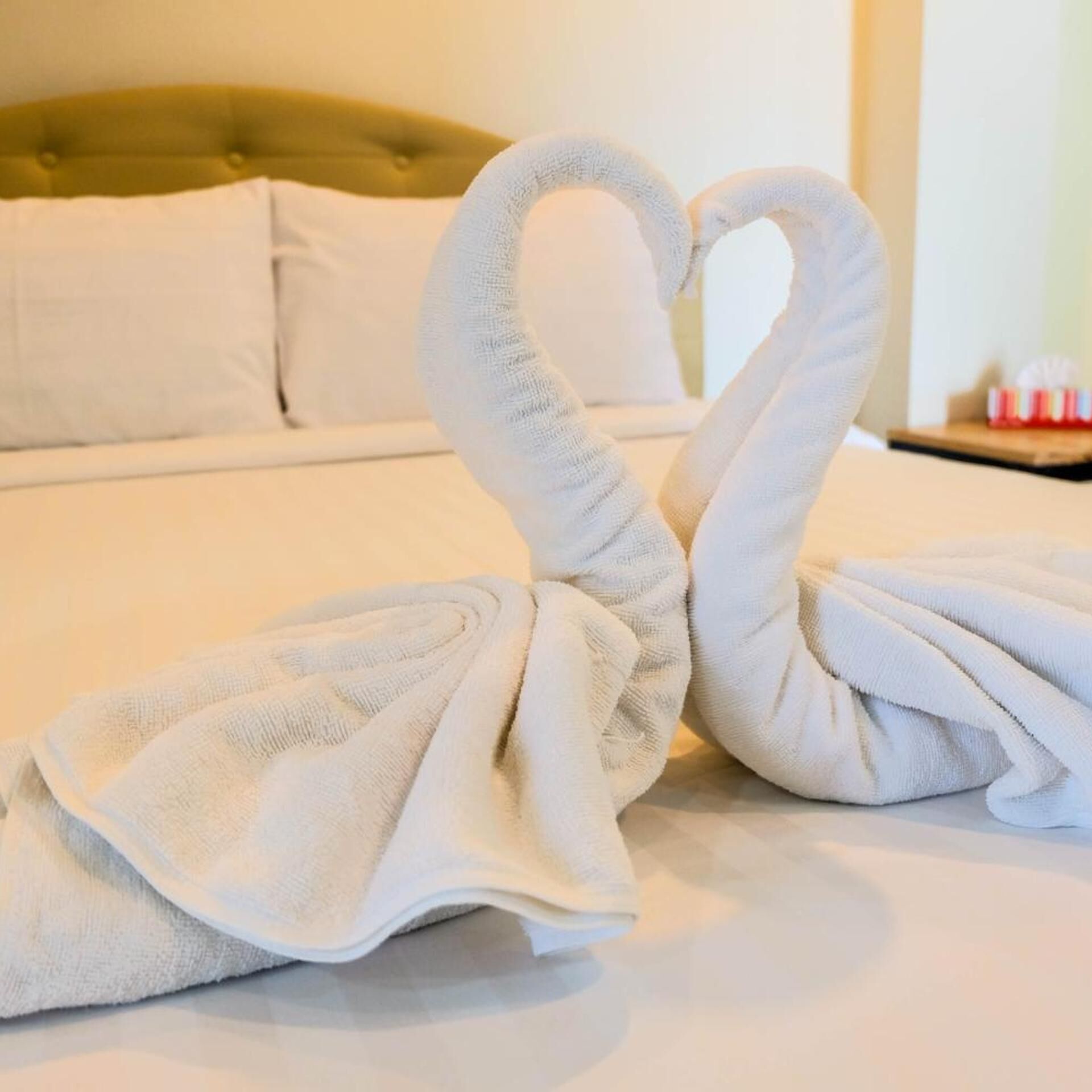 A bed with a tufted headboard and white linens.
