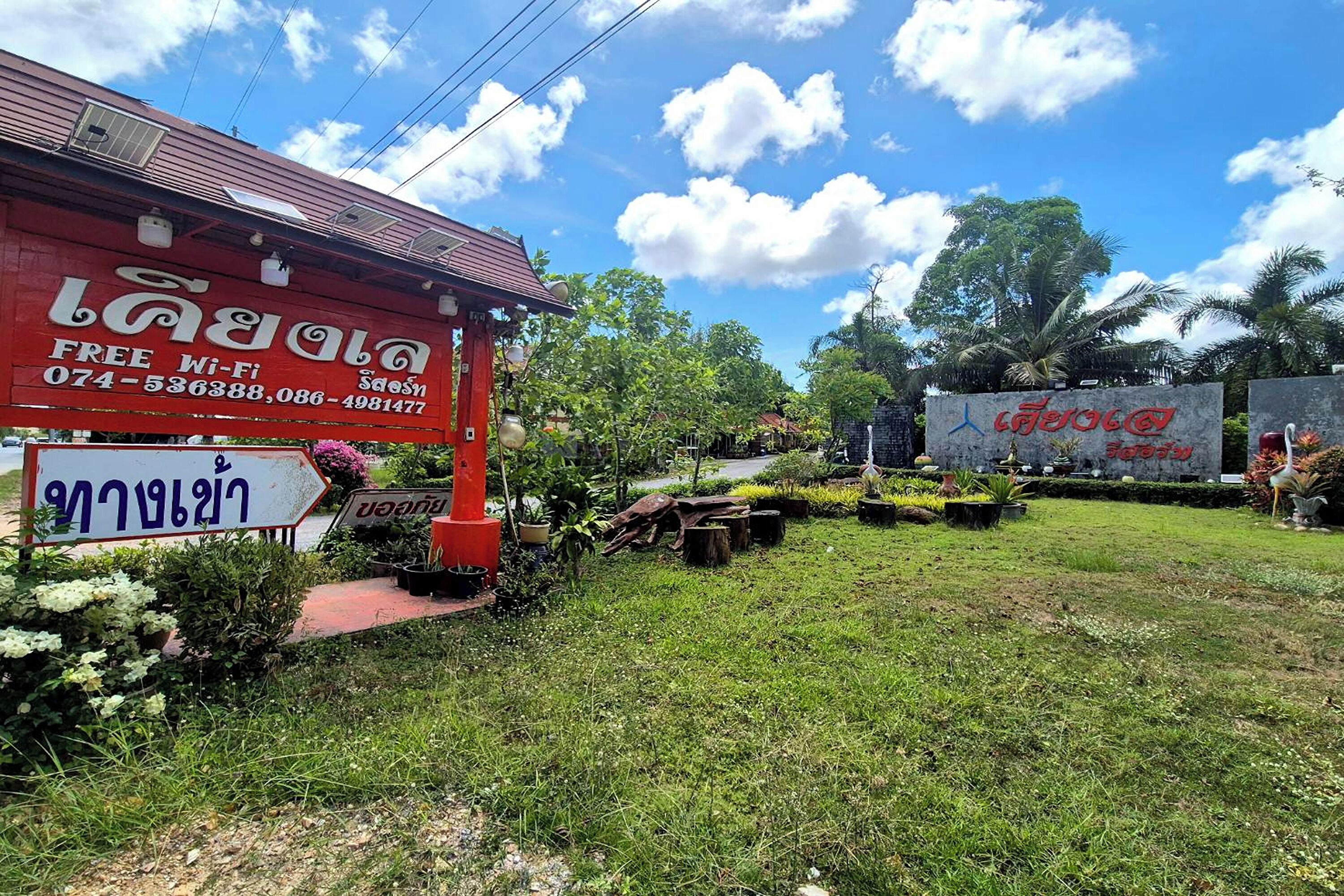 A red building with a sign offering free Wi-Fi and contact numbers.