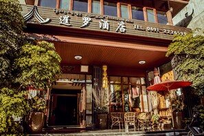 Ein Hotel mit Eingang, Außenbereich und Blumentöpfen.