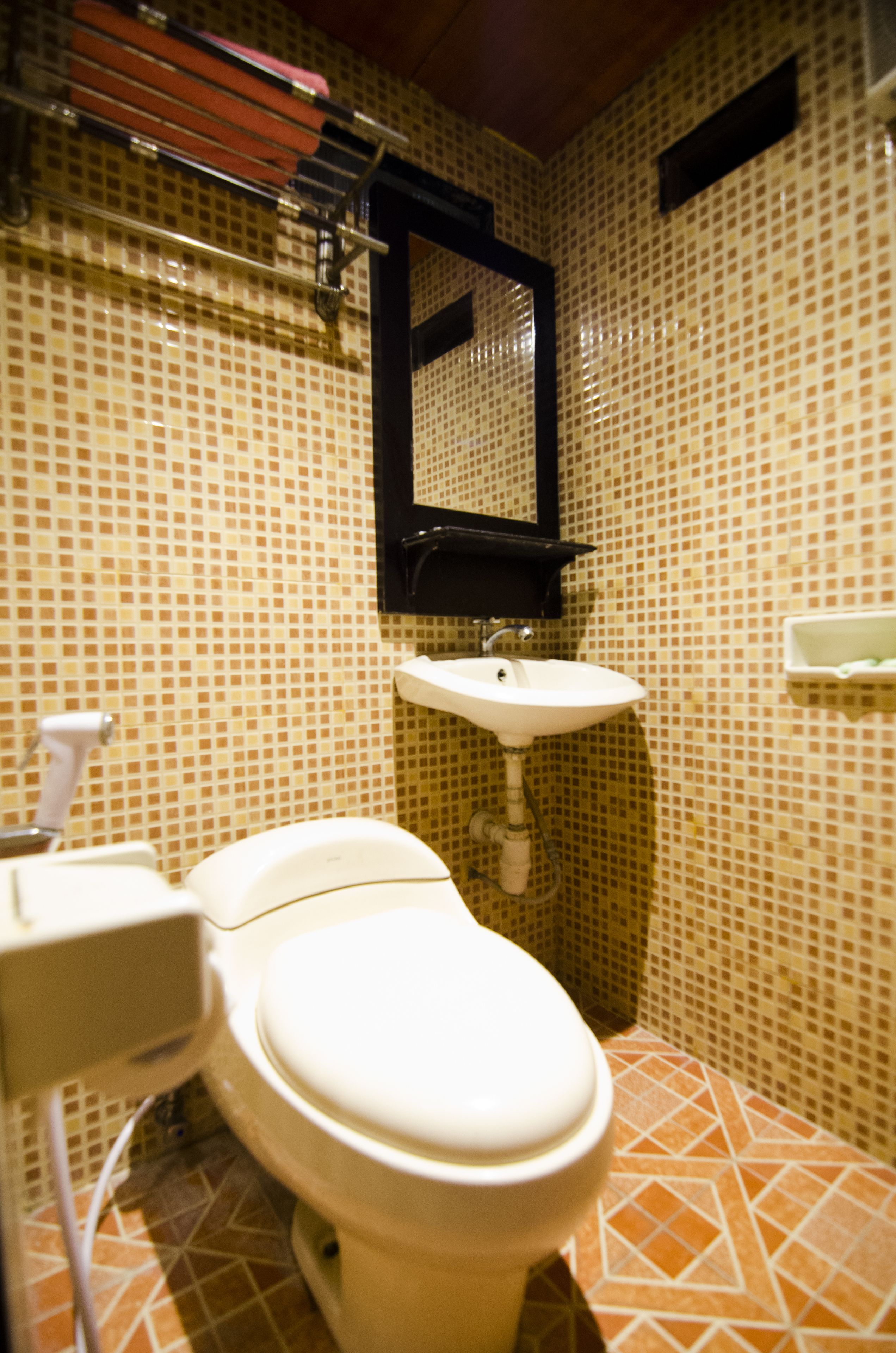 A bathroom with a toilet, sink, and tiled walls.
