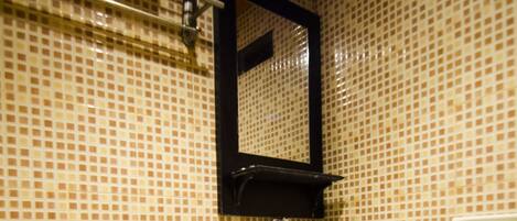 A bathroom with a toilet, sink, and tiled walls.