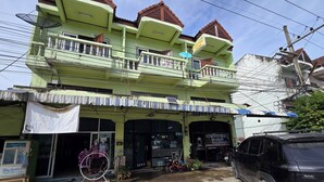 A multi-story building with balconies, a storefront, and a parked SUV. - Malai Place Lampang (Lampang)