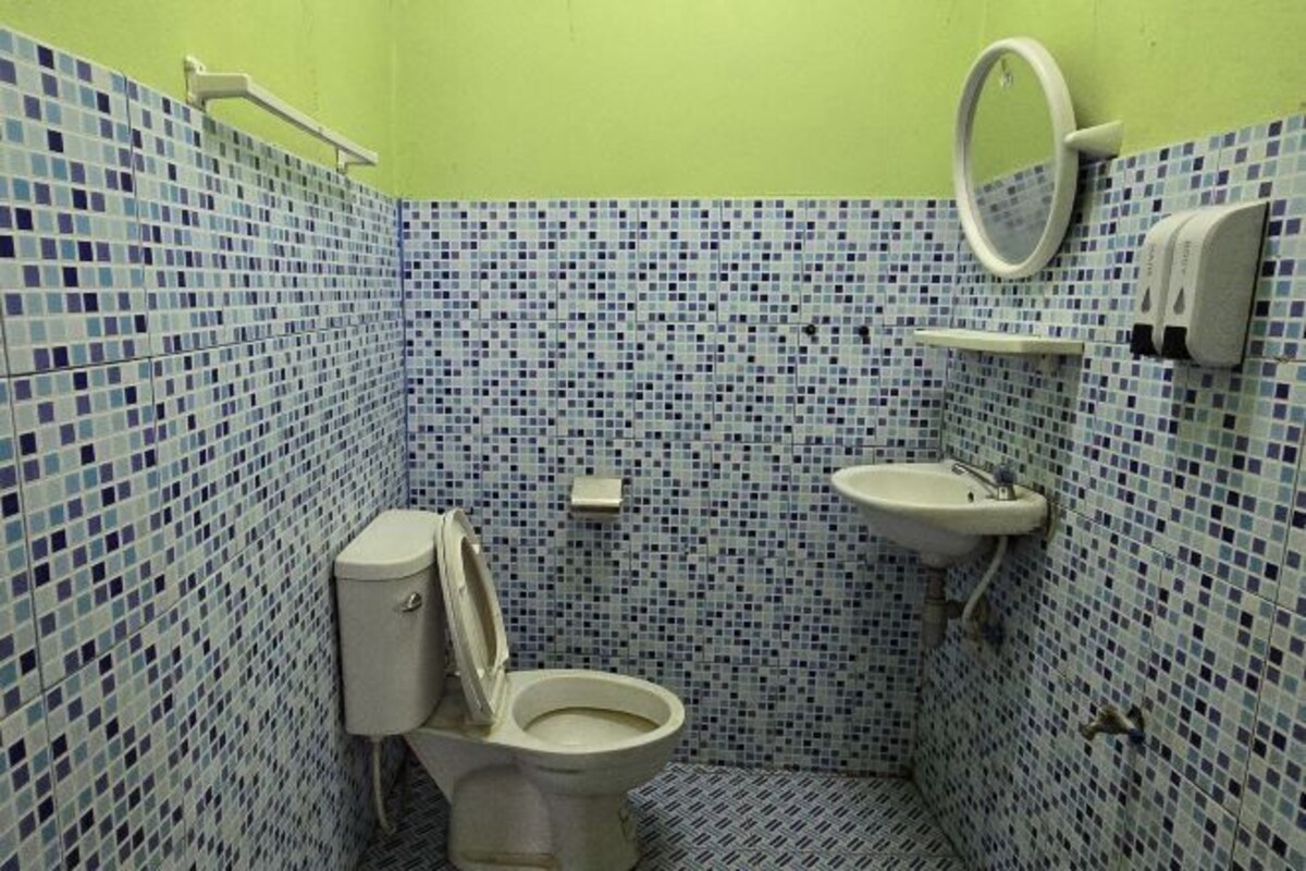 A bathroom with a toilet, sink, and mirror.