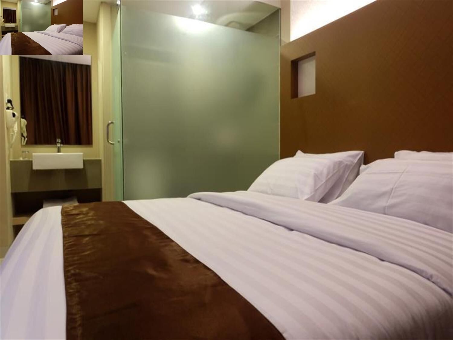 A hotel room with a bed, a bathroom with a sink, and a door leading to another room.