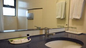 A bathroom with a sink, mirror, and towel rack. - Fabhotel Check'in By Oran (New Delhi)