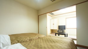 A hotel room with two beds, a TV, and a window providing natural light. - Royal Inn Mito (Mito)