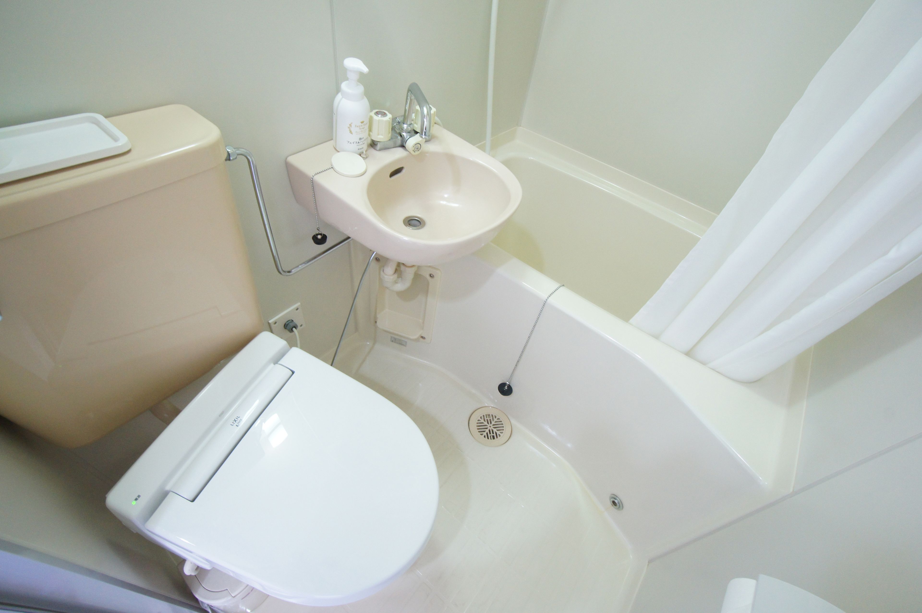 A bathroom with a toilet, sink, and bathtub.