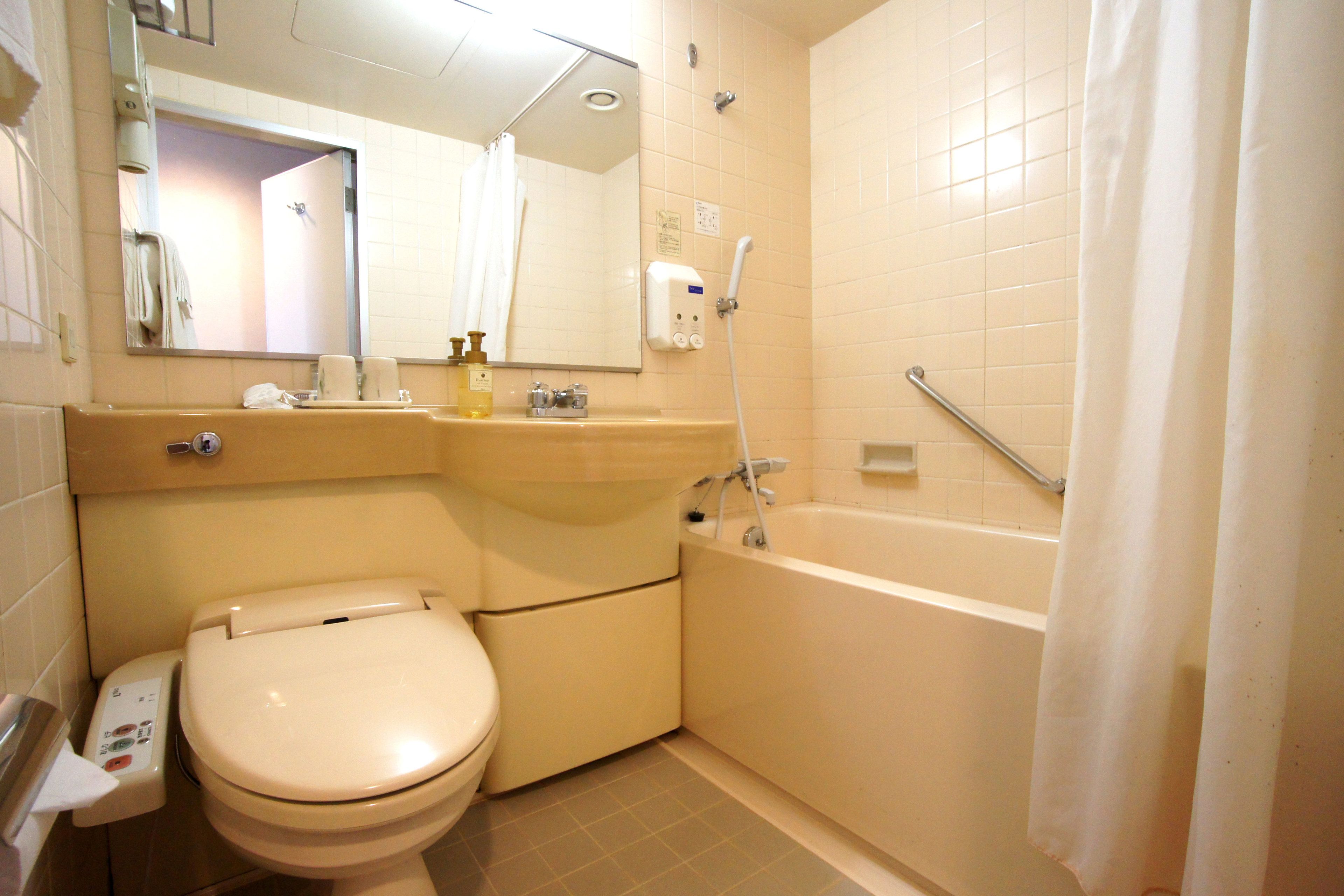 A bathroom with a toilet, sink, and bathtub.