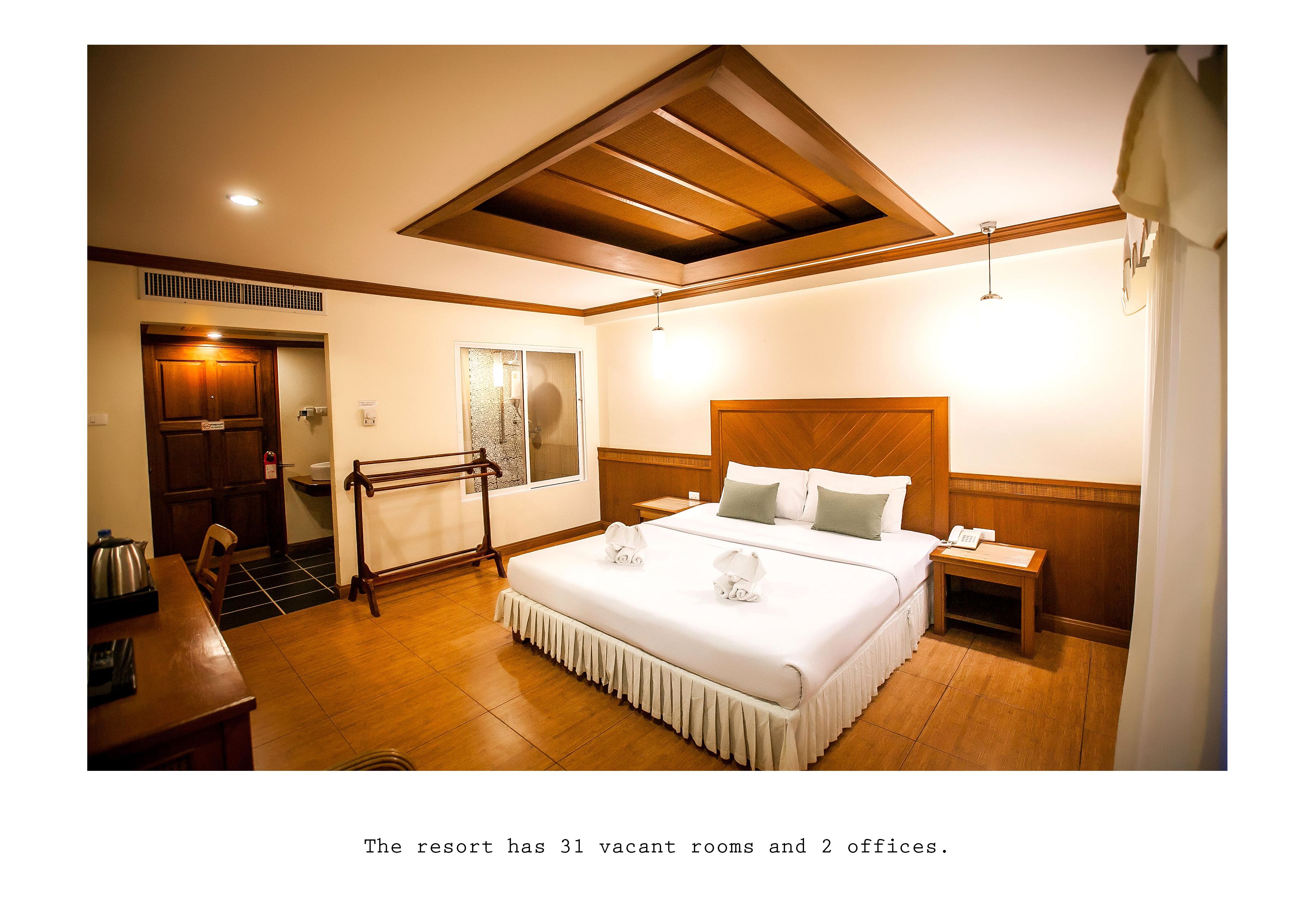 Una habitación de hotel con una cama, mesita de noche y techo de madera.