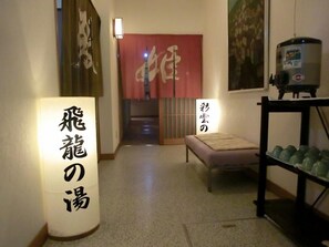 A hallway with a tatami mat room, a traditional Japanese room, and a water dispenser.