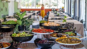 Un buffet allestito con diversi piatti e una persona che si muove sullo sfondo.