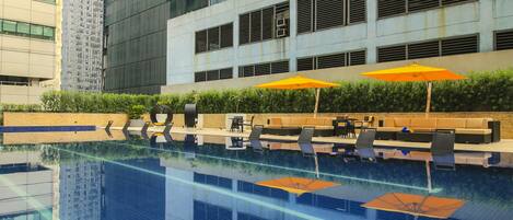 Un edificio moderno con una piscina reflectante al frente.
