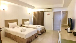Una habitación de hotel con dos camas, televisión, escritorio y baño.