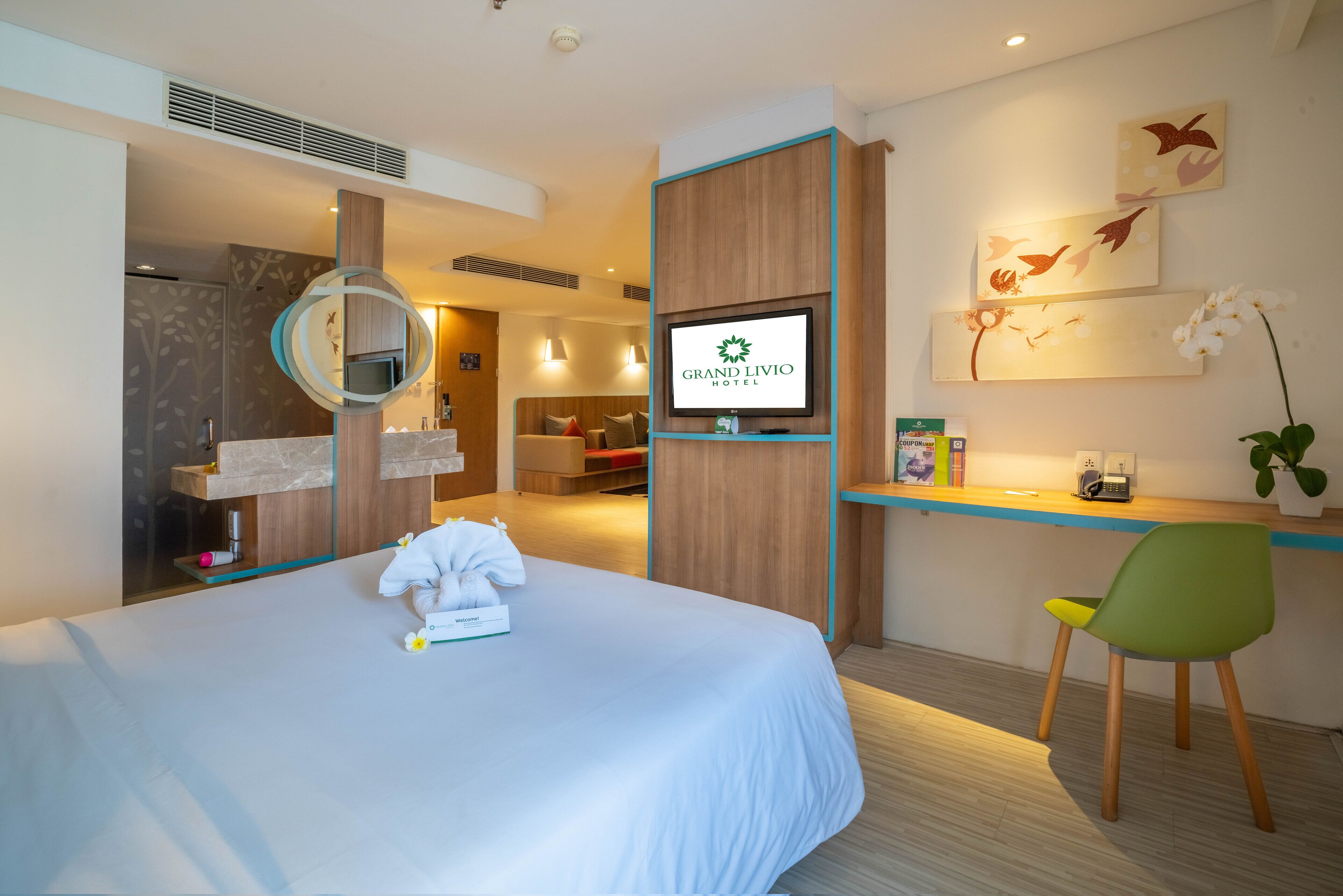 Una habitación de hotel con cama, escritorio, televisor y baño.