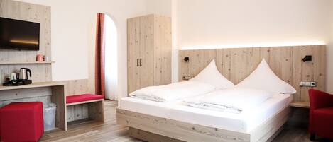 Una habitación de hotel moderna con una cama de madera, un televisor de pantalla plana, un escritorio y una silla roja.
