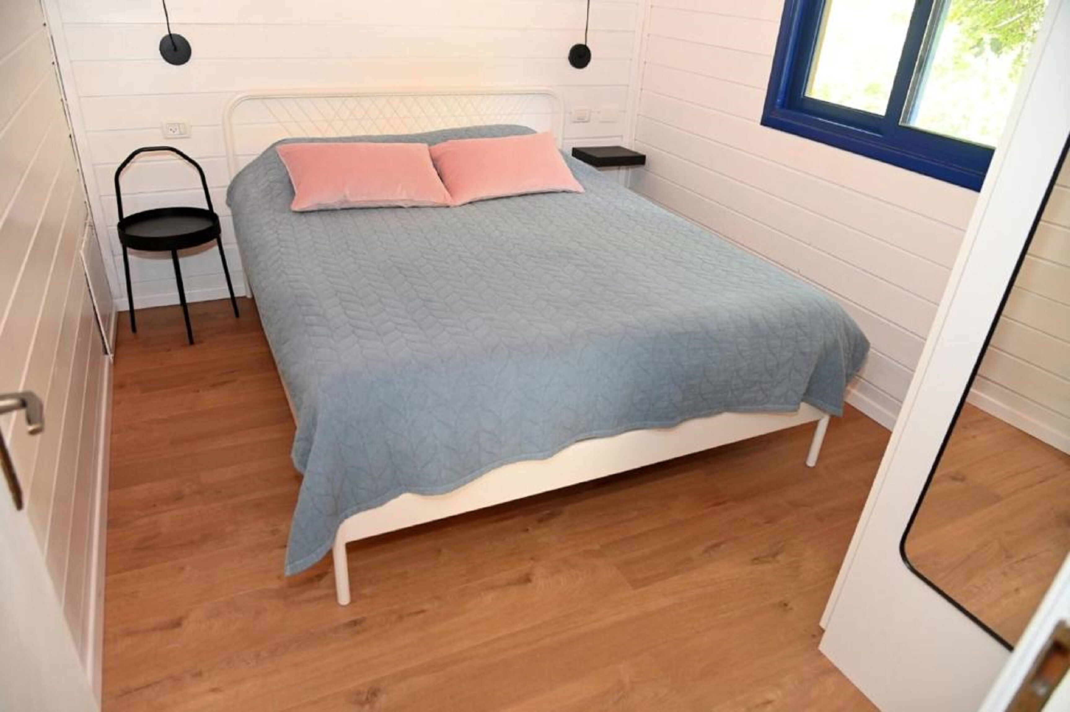 Ein Schlafzimmer mit einem Bett, einem Sessel und einem Fenster.