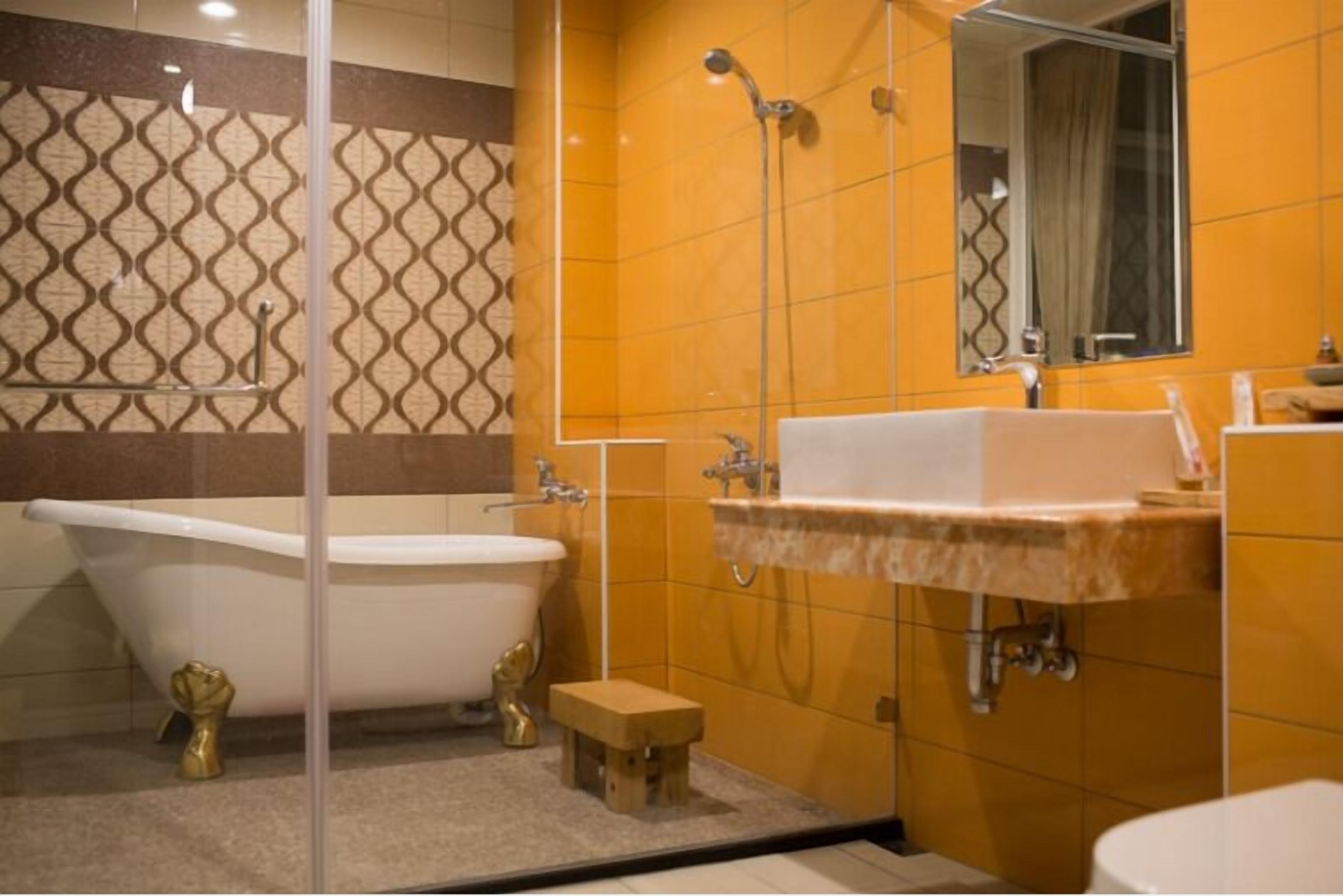 A bathroom with a freestanding bathtub, a sink, and a mirror.
