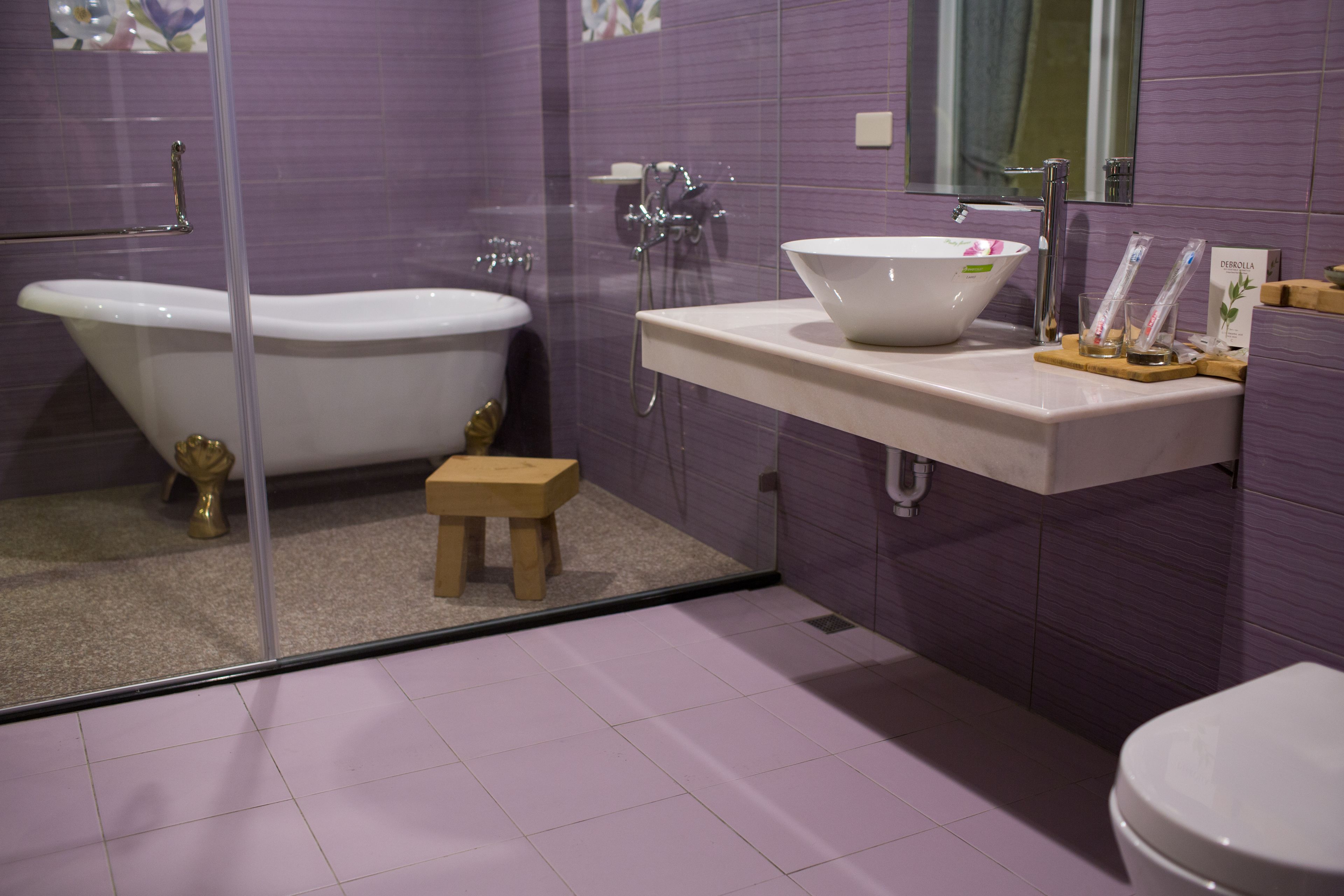 A bathroom with a freestanding bathtub, a sink with a basin, and a toilet.