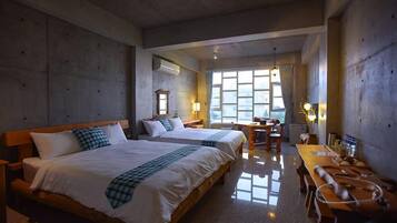 Ein Hotelzimmer mit zwei Betten, einem Holztisch und einem Fenster mit Vorhängen.