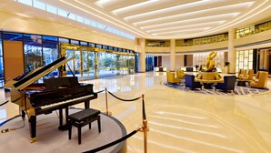 A grand lobby with a grand piano, a reception desk, and a seating area with sofas and chairs. - Grand Skylight Int'l Hotel Huizhou (Huizhou)