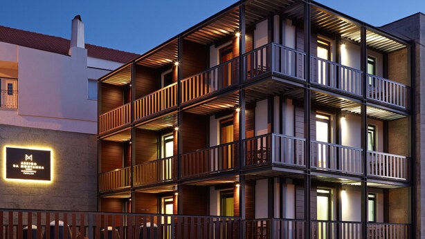 Un hôtel à plusieurs étages doté de balcons, une enseigne indiquant qu’il s’agit d’un établissement accueillant les familles, et une façade bien éclairée.
