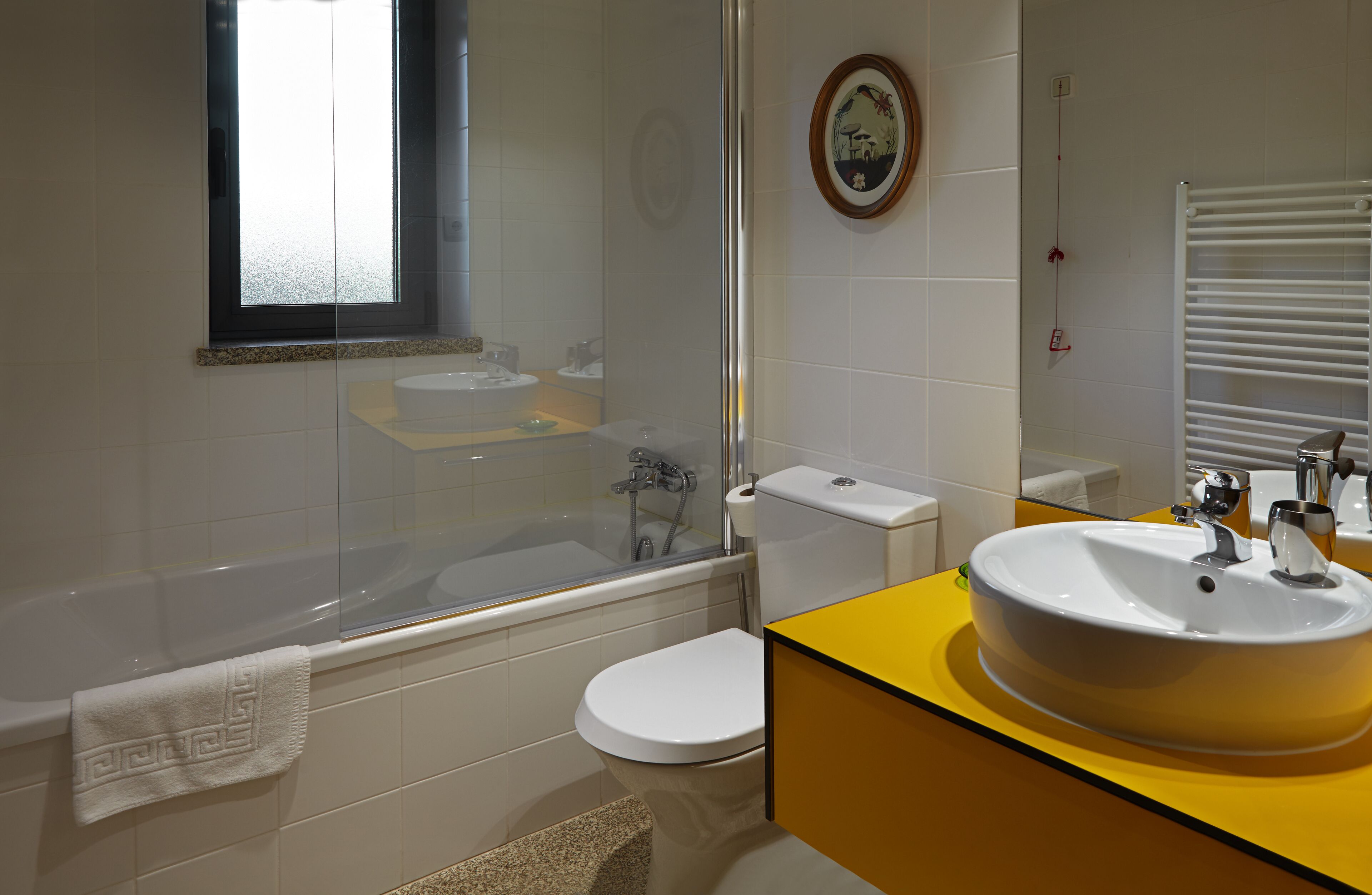 Un baño con bañera, inodoro y lavamanos.