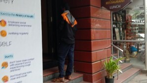 A person exiting a building with a sign for 'Dukadila Pizzeria' on the right. - Taj Mahal Hotel Abids (Hyderabad)