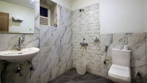 A bathroom with a sink, toilet, and shower. - Taj Mahal Hotel Abids (Hyderabad)