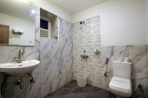 Un baño con lavamanos, inodoro y ducha.