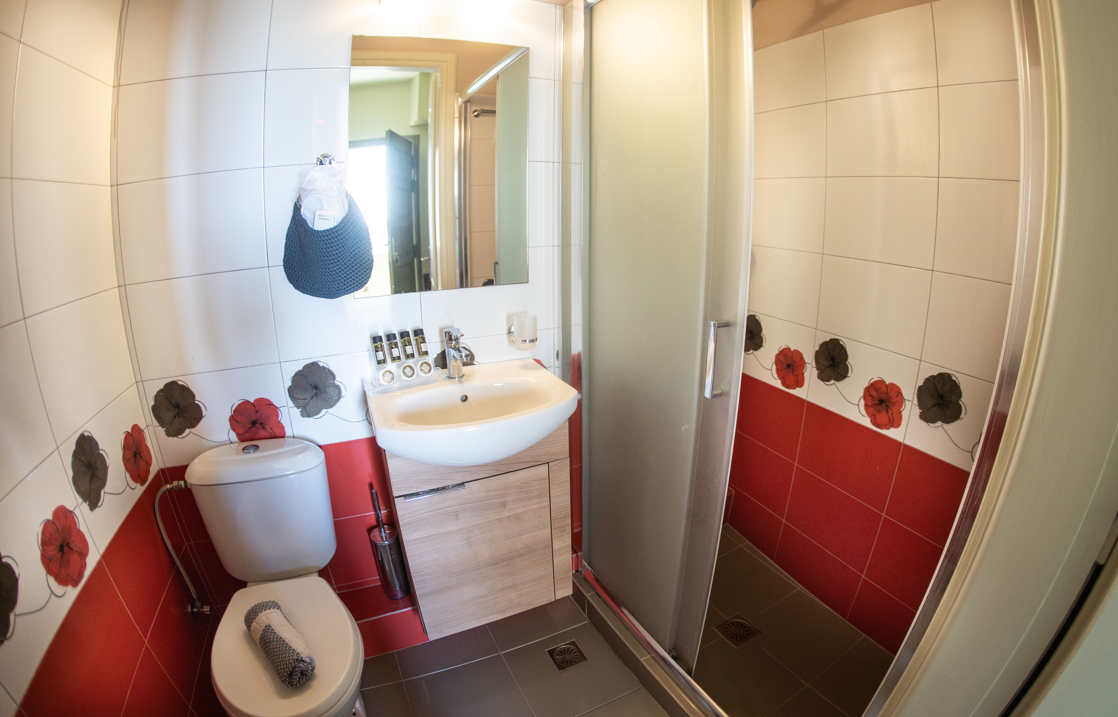 A bathroom with a toilet, sink, and shower.