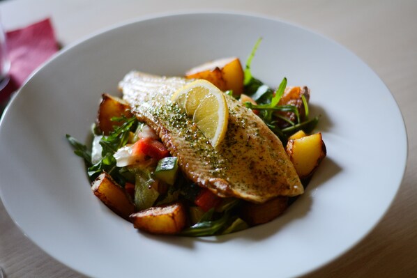 Prato de peixe com limão e legumes.