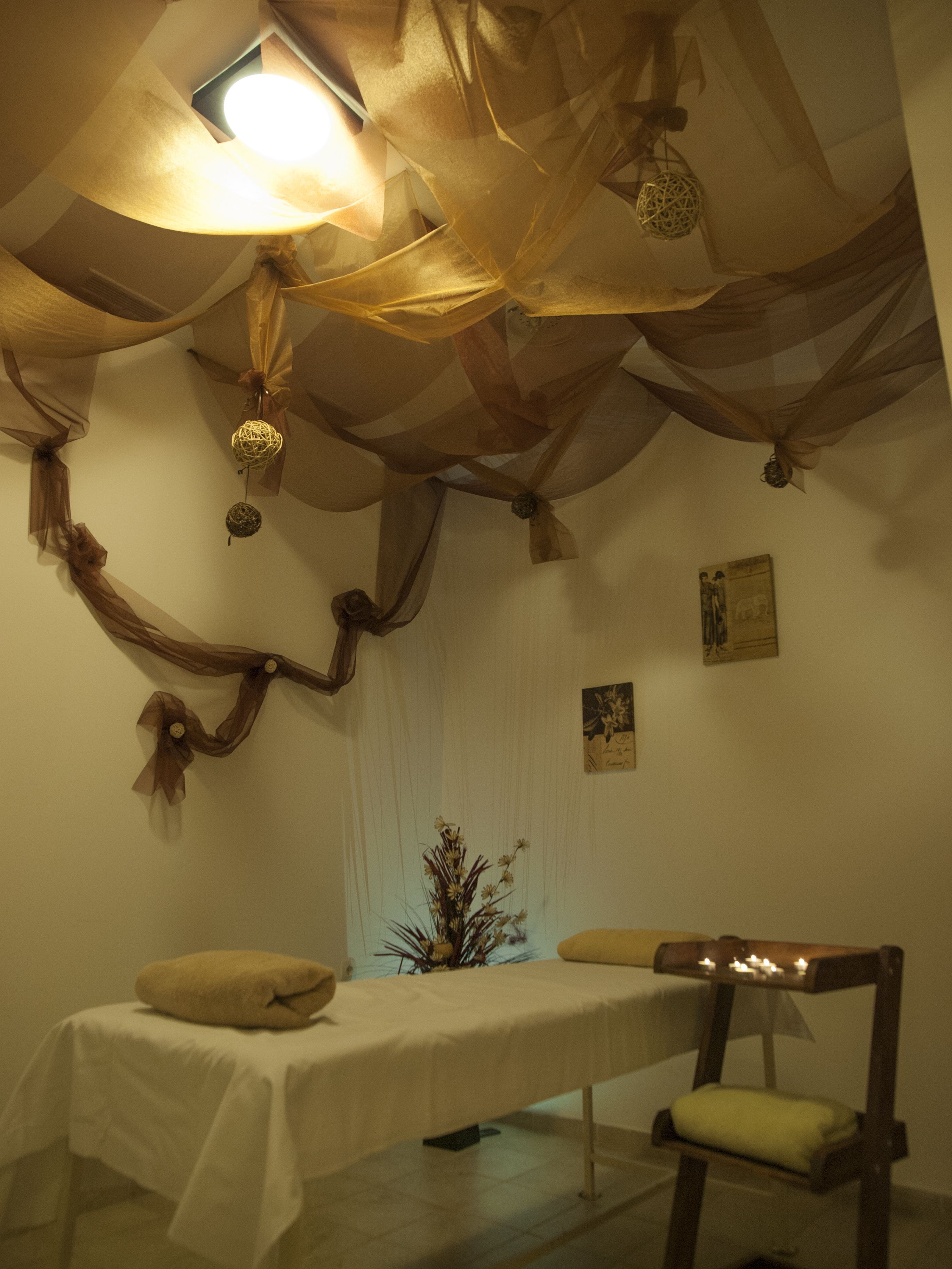 Una habitación con una cama, una silla y una mesa con velas.