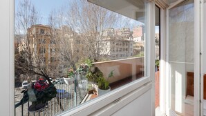 Un balcó amb plantes en testos i vista a edificis.