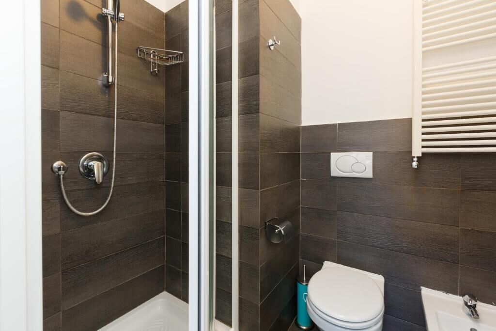 A bathroom with a shower, toilet, and sink.